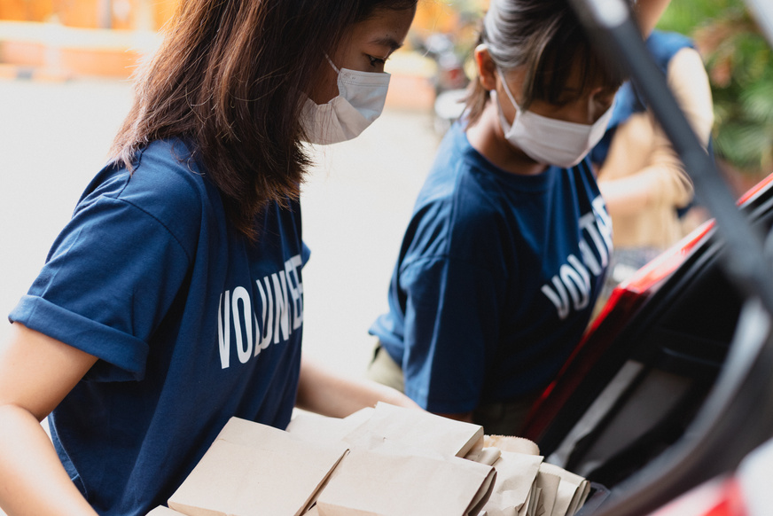 Volunteers with Packed Food Loading it into Car Trunk
